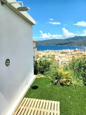 a backyard with a bench and a view of the water at Casa di l'Alivi - Villa avec vue exceptionnelle in Propriano