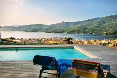a swimming pool on a deck with a view of the water at Casa di l'Alivi - Villa avec vue exceptionnelle in Propriano