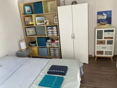 a bedroom with a bed and a white cabinet at F3 hyper centre vieille ville coeur historique d'Ajaccio in Ajaccio