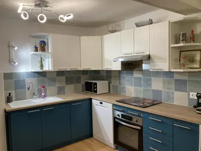 a kitchen with blue and white cabinets and a sink at F3 hyper centre vieille ville coeur historique d'Ajaccio in Ajaccio