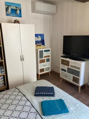 a bedroom with a bed and a tv and a dresser at F3 hyper centre vieille ville coeur historique d'Ajaccio in Ajaccio