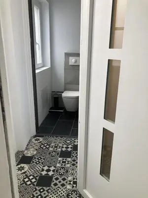 a bathroom with a toilet and a black and white tile floor at F3 hyper centre vieille ville coeur historique d'Ajaccio in Ajaccio