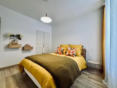 a bedroom with a bed with yellow sheets and pillows at Magnifique deux pièces au cœur d Ajaccio in Ajaccio