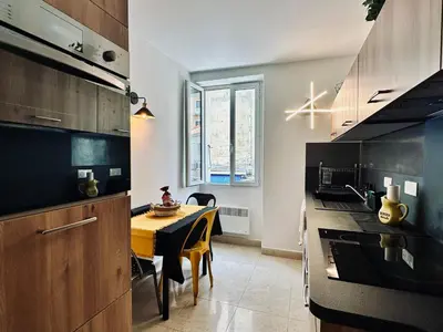 a kitchen with a table and a dining room at Magnifique deux pièces au cœur d Ajaccio in Ajaccio