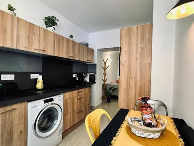 a kitchen with a washing machine and a table at Magnifique deux pièces au cœur d Ajaccio in Ajaccio
