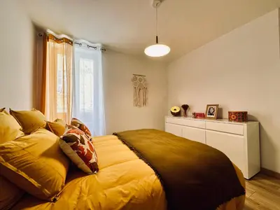 a bedroom with a large bed with yellow sheets at Magnifique deux pièces au cœur d Ajaccio in Ajaccio