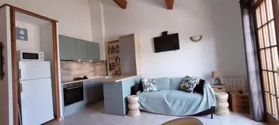 a kitchen with a blue couch in a room at Appartement Papillon avec Piscine et Vue Mer in Propriano