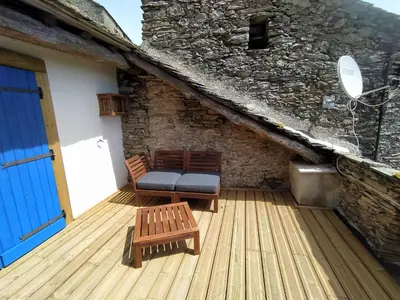a wooden deck with two chairs and a blue door at Sole e Ventu in Velone-Orneto