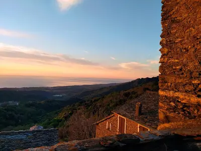 a building sitting on top of a mountain at sunset at Sole e Ventu in Velone-Orneto