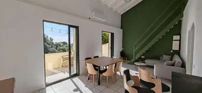 a dining room with a table and chairs and a couch at Villa familiale superbe vue mer et couchers de soleil in Pietrosella