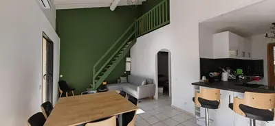 a kitchen and dining room with a green wall at Villa familiale superbe vue mer et couchers de soleil in Pietrosella