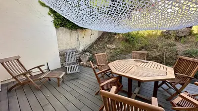 a wooden table and chairs on a deck at Villa familiale superbe vue mer et couchers de soleil in Pietrosella