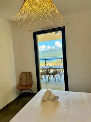 a bedroom with a bed and a view of the ocean at Appartement confort vue mer in Propriano