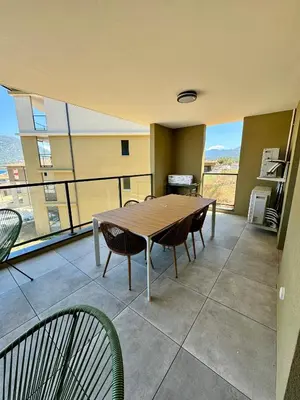 a dining room with a table and chairs on a balcony at Appartement confort vue mer in Propriano