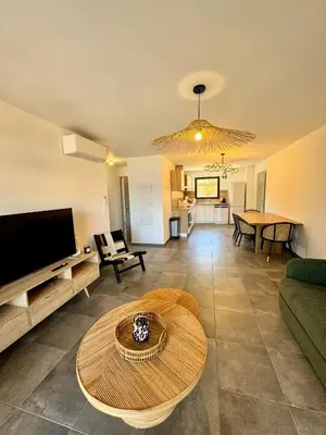 a living room with a couch and a table at Appartement confort vue mer in Propriano