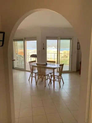 a dining room with a table and some chairs at Les Cistes Appt type 3 avec terrasse vue sur mer in Propriano
