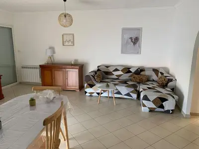 a living room with a couch and a table at Les Cistes Appt type 3 avec terrasse vue sur mer in Propriano