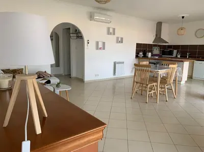 a kitchen and dining room with a table and chairs at Les Cistes Appt type 3 avec terrasse vue sur mer in Propriano