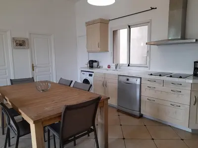 a kitchen with a wooden table and a table and chairs at Villa EDEN BLUE in Zonza
