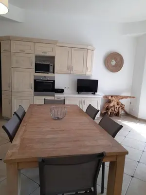 a kitchen with a wooden table with chairs around it at Villa EDEN BLUE in Zonza