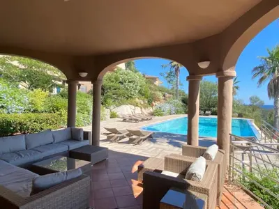 a patio with a couch and a swimming pool at Villa EDEN BLUE in Zonza
