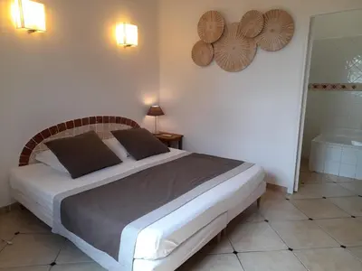 a bedroom with a large bed and a bath tub at Villa EDEN BLUE in Zonza