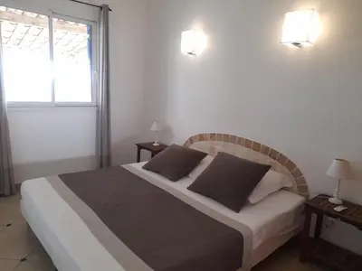 a bedroom with a bed with two tables and a window at Villa EDEN BLUE in Zonza