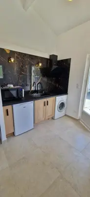 a kitchen with a sink and a washing machine at Studio folelli entre le centre et la plage in Penta-di-Casinca