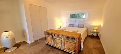 a small bedroom with a bed and a window at Villa U Caseddu - Vue mer, évasion et confort in Bonifacio