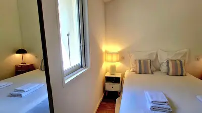 a bedroom with a large white bed with a window at Villa U Caseddu - Vue mer, évasion et confort in Bonifacio