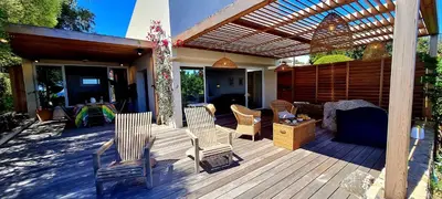 a wooden deck with chairs and a pergola at Villa U Caseddu - Vue mer, évasion et confort in Bonifacio