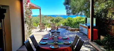 a table and chairs on a patio with a view at Villa U Caseddu - Vue mer, évasion et confort in Bonifacio