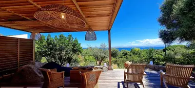a patio with chairs and a table with a view at Villa U Caseddu - Vue mer, évasion et confort in Bonifacio