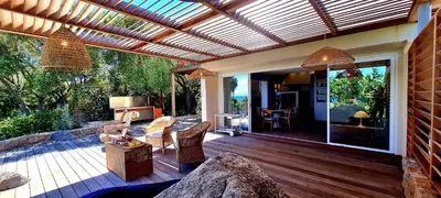 an outdoor patio with a wooden deck with a pergola at Villa U Caseddu - Vue mer, évasion et confort in Bonifacio