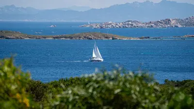 a sail boat in the middle of a large body of water at Villa U Caseddu - Vue mer, évasion et confort in Bonifacio