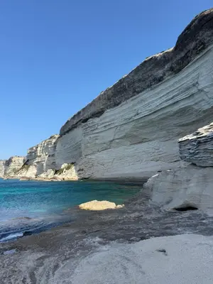 a rock wall next to the water and the ocean at Casa Felicia in Bonifacio