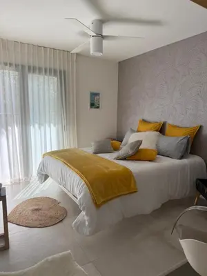 a bedroom with a large bed with yellow and gray pillows at Casa Felicia in Bonifacio