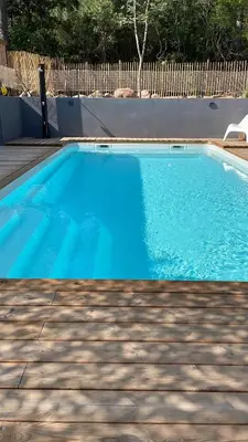 a blue swimming pool in a yard with a fence at Casa Sophie in Capo