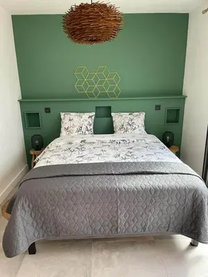 a bedroom with a large bed with a green wall at Casa Sophie in Capo