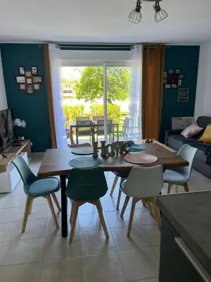 a dining room with a wooden table and chairs at Les villas de Melody in Santa-Maria-Poggio