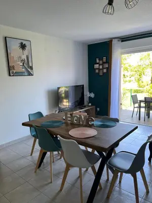 a dining room with a wooden table and chairs at Les villas de Melody in Santa-Maria-Poggio