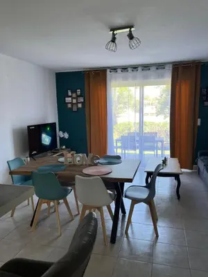 a living room with a dining room table and chairs at Les villas de Melody in Santa-Maria-Poggio