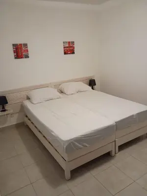 a white bed in a room with a white wall at Les villas de Melody in Santa-Maria-Poggio