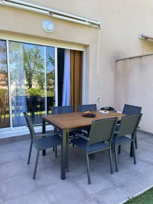 a wooden table and chairs on a patio at Les villas de Melody in Santa-Maria-Poggio