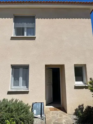 a building with a door and two windows at Les villas de Melody in Santa-Maria-Poggio