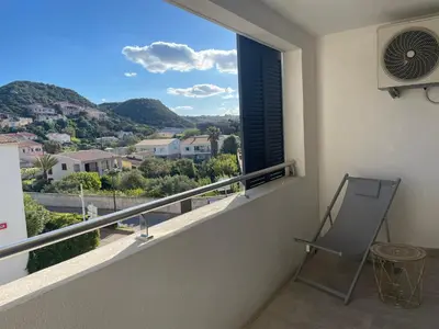 a balcony with a chair and a window with a view at T2 neuf port de Bonifacio avec parking privé in Bonifacio