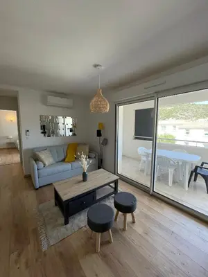 a living room with a couch and a table at T2 neuf port de Bonifacio avec parking privé in Bonifacio