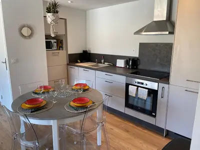 a kitchen with a table and chairs in a kitchen at T2 neuf port de Bonifacio avec parking privé in Bonifacio