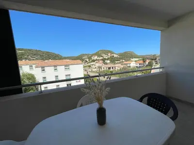 a vase on a table on a balcony with a view at T2 neuf port de Bonifacio avec parking privé in Bonifacio