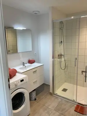 a bathroom with a washing machine and a shower at T2 neuf port de Bonifacio avec parking privé in Bonifacio